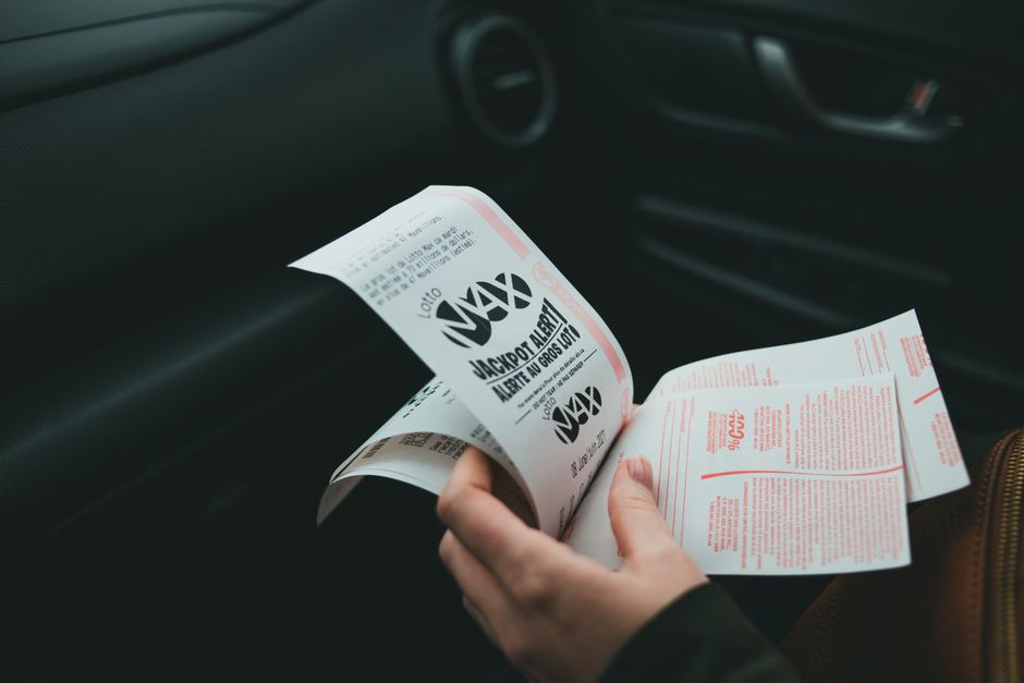 person holding winning lottery ticket claim form office